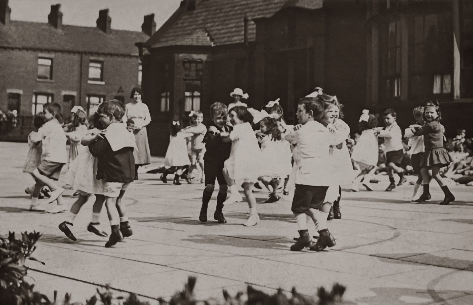 gray scale photo of children dancing on street